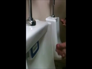 two slim dicks getting wanked at the urinals